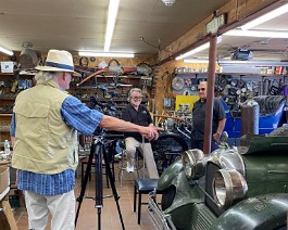 2022 Cruising New England with Paul Mennett 2022-07-10 2557 Film crew director pointing to Dick's 1926 Model A Duesenberg in Dick's shop.